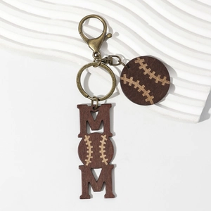 Close-up of MOM wooden keychain with baseball pattern on white stone background