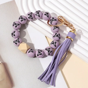 Bracelet porte-clés perles en bois violettes motif papillon et pompon en cuir
