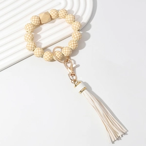 Checkered wooden bead keychain with white PU tassel and gold clasp on white background