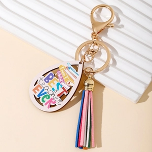 Detail of wooden teardrop keychain for teachers with rainbow lettering and colorful tassel