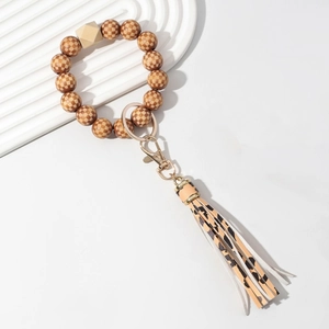 Detail of wooden checkered beads, leopard print fringe, and gold metal lobster clasp