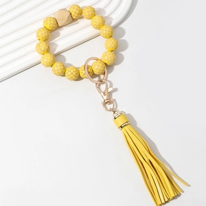 Detail of yellow plaid wooden beaded keychain with gold metal clasp and long PU tassel