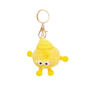 Cute yellow plush monster keychain with knit hat and spring limbs on white background