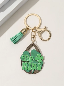 Detail of St. Patrick's Day wood clover keychain with green tassel and Be Mine text