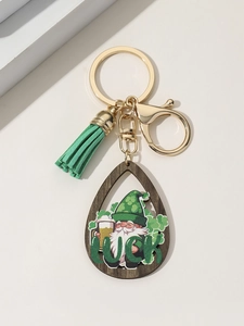 Detail of St. Patrick's Day wood keychain with gnome, green tassel, and Luck lettering