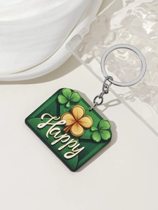 Macro detail of St. Patrick's Day green clover keychain with Happy text on silky background