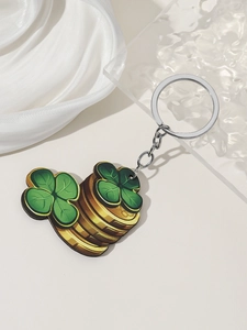 Detail of St. Patrick's Day keychain featuring green clovers and gold coins on white silk