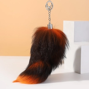 Macro shot of faux fox fur keychain showing striped brown and orange plush textures