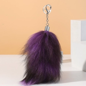 Macro detail of plush faux fox tail keychain with purple-black gradient and metal hook