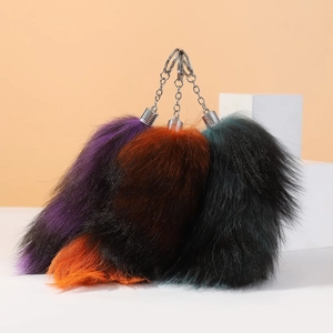Detailed plush faux fox tail keychains in purple, orange, and green with metal clips