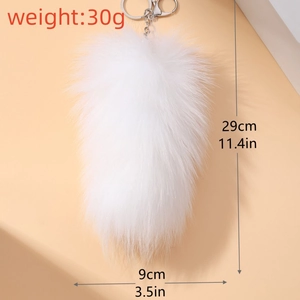 Detailed view of large white fluffy faux fur tail keychain with silver metal ring and clip