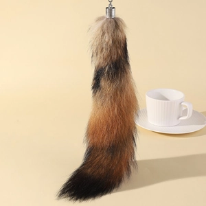 Detailed macro view of soft faux fox tail keychain with a stylish tri-color gradient effect