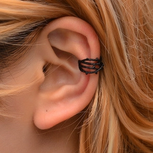 Detailed view of matte black vine thorn ear cuff clip on female model ear bone