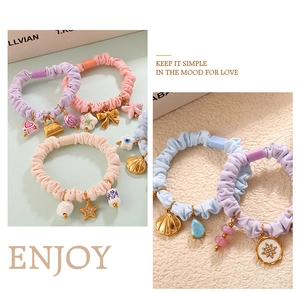 Detail of colorful macaron scrunchies with cute metal pendants and heart star charms
