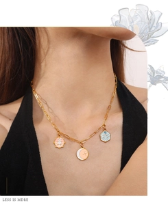 Detail of paperclip chain necklace with colorful celestial moon and star enamel pendants