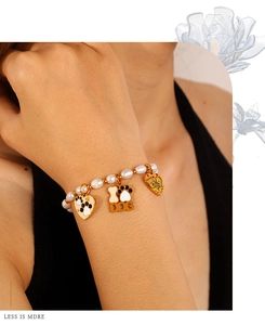 Détail d'un bracelet en perles avec cœurs émaillés et breloques sur le thème du chien