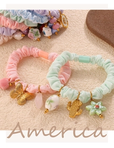Detail of pink and mint green scrunchies with golden butterfly and cactus charms