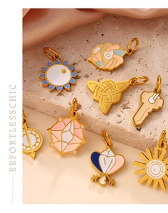 Macro shot of gold-plated enamel pendants in moon, sun, and rose shapes for DIY jewelry