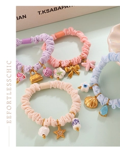 Detailed view of pastel scrunchies featuring floral and starfish charms with soft fabric