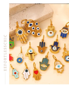 Detailed macro view of gold Hamsa hand and evil eye pendants with enamel and crystals