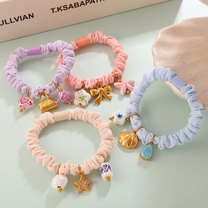 Macaron color scrunchie set with assorted charms like stars, hearts, and ceramic flowers