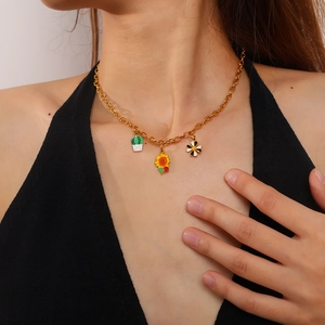 Collana a catena dorata con ciondoli smaltati a cactus e girasole su una modella