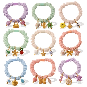 Pastel macaron scrunchies with floral and cactus charms in a 3x3 layout display
