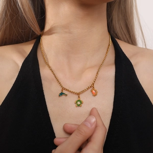 Gold necklace featuring dolphin, turtle and crab charms on a model with black top