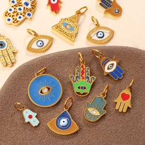 Golden Hamsa Hand and Evil Eye jewelry pendants in bohemian style with enamel details