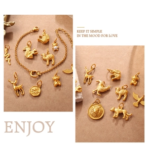 Detailed view of high-quality gold animal charms with pearls on a textured background