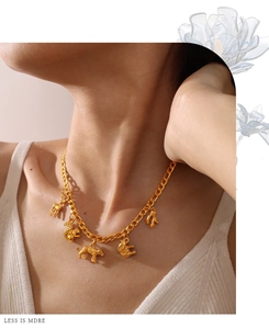 Close-up of a gold necklace featuring multiple detailed animal charms on a thick chain