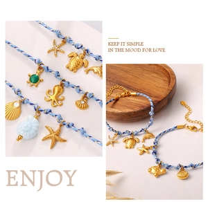 Close-up of ocean-themed blue braided bracelet with starfish and dolphin charms