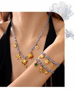 Detail of ocean-themed jewelry with sea turtle and dolphin charms on blue woven cord