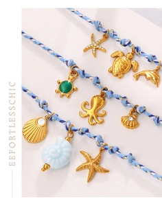Detail view of ocean-themed braided blue cord necklaces with starfish and sea turtle pendants