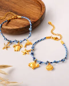 Detailed shot of blue braided bracelets with gold starfish, turtle and dolphin charms