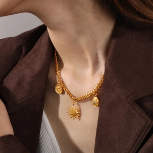 Goldene grobe Gliederkette mit Sonne- und Mondanhängern an einem Model getragen