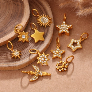 Set aus goldenen Anhängern mit Sternen, Mond und Engeln, verziert mit funkelnden Strasssteinen