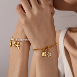 Elegantes Set aus goldenen Layering-Armbändern mit Perlen und Diamant-Anhängern