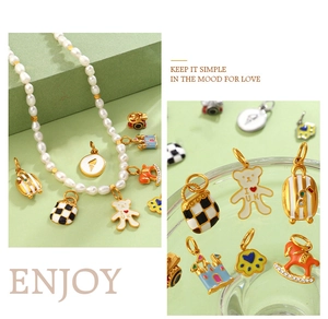 Detail of pearl necklace featuring colorful enamel castle, rocking horse, and suitcase charms