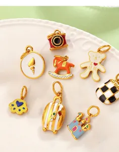 Detailed shot of assorted enamel charms including a castle and teddy bear on a white plate