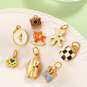 Assorted colorful enamel charms including castle and rocking horse on a white plate