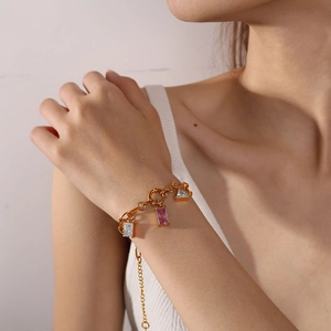 Elegantes Goldarmband mit rosa und klaren Zirkonia-Anhängern am Handgelenk des Models