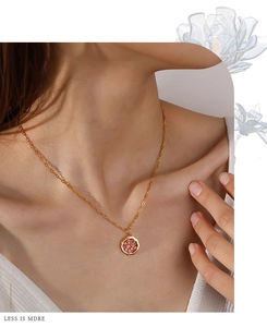 Gros plan d'un collier en chaîne dorée avec pendentif burger en émail sur un mannequin
