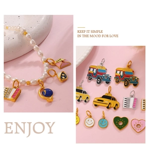 Close-up of pearl bracelet with enamel charms including heart, taxi and globe pendants