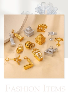 Macro detail of 18K gold and silver charms including Eiffel Tower and various shapes
