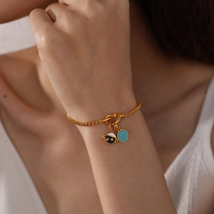 Gold charm bracelet with light blue smiley face and dark blue star planet pendants