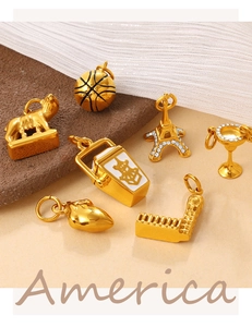 Detailed view of 18K gold plated charms including Eiffel Tower and takeout box with crystals