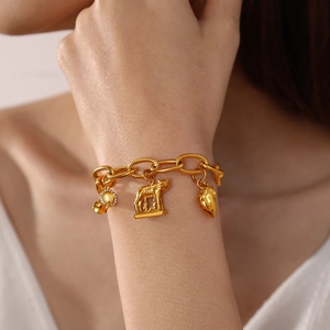 18K gold plated chunky chain bracelet with Roman wolf and heart charms on wrist