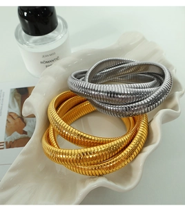 Dettaglio di bracciali a triplo strato con trama a serpente oro e argento in piatto a conchiglia