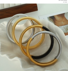 Macro view showing various colors of elastic snake bone metal bracelets on a shell tray